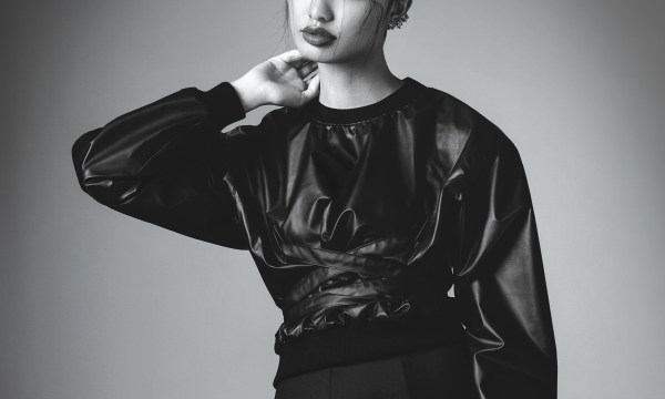 Portrait of asian fashionable woman wearing black leather top and skirt. Professional make-up and hairstyle.